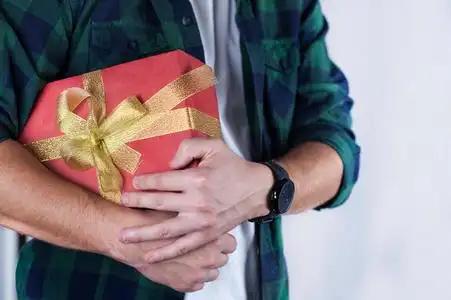 年轻的帅哥手里拿着礼物特写照片